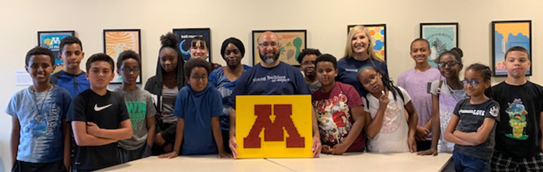 The group with the final LEGO completion of the M of the University of Minnesota.